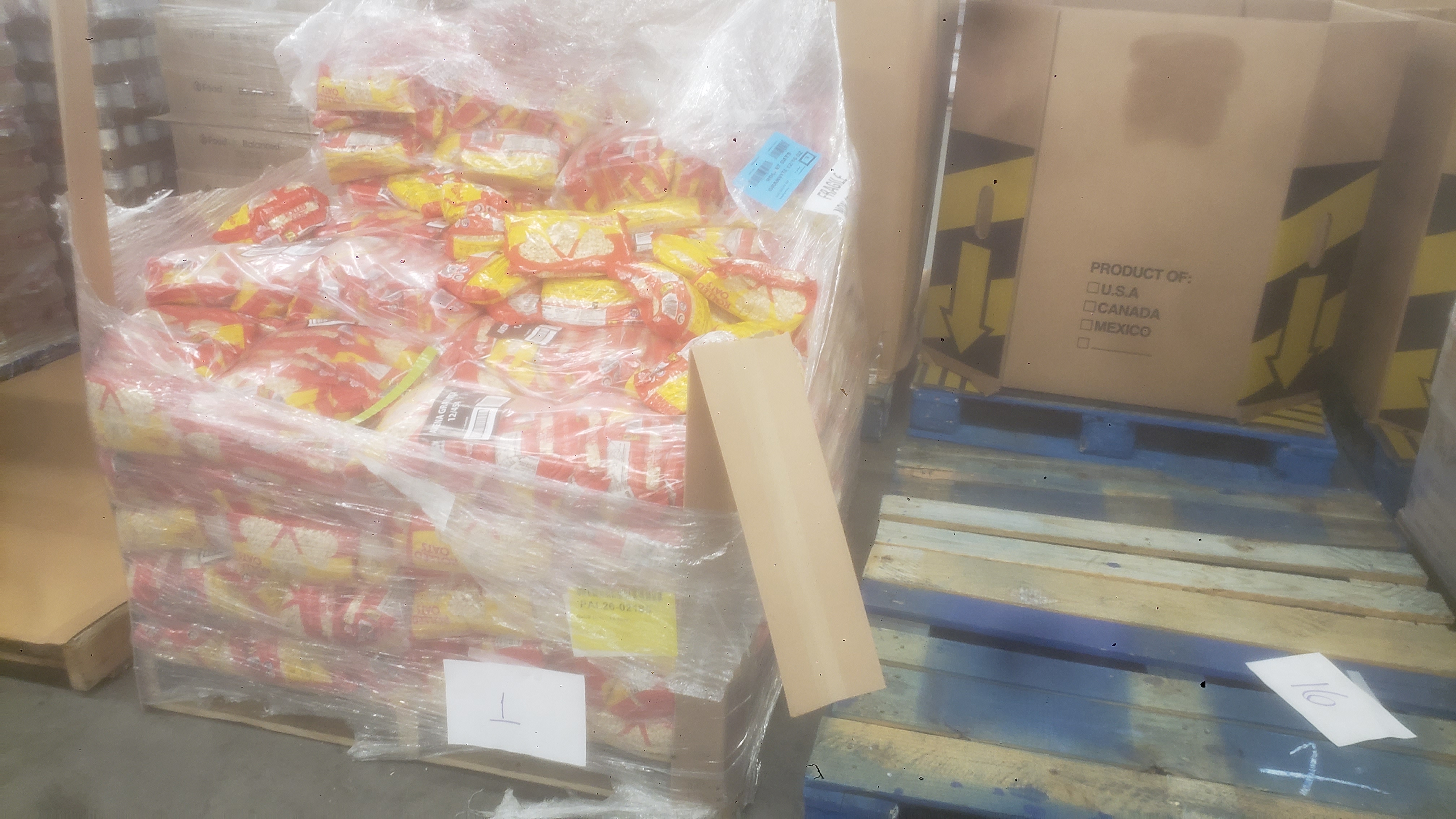 Pallet of bags of oatmeals next to pallets.